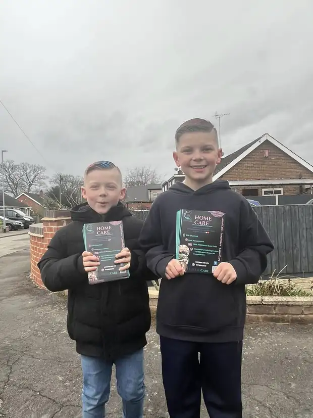 Two children holding Luxuricare home care leaflets on a residential street
